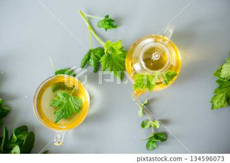 Natural green tea with herbs in glass on a gray background 134596073