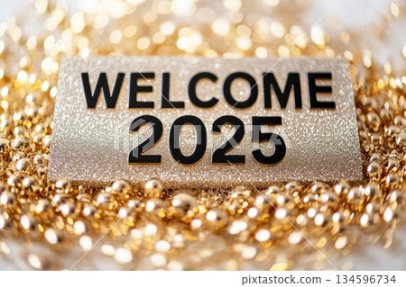 welcome 2025 text isolated on a glowing gold glitter background, symbolizing New Year celebrations and holiday cheer for welcoming 2025. 134596734