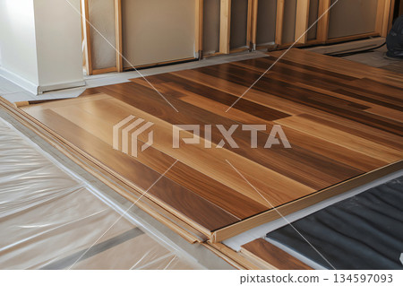 Laminate flooring being installed in a room under renovation, showcasing the process of home improvement and interior design 134597093