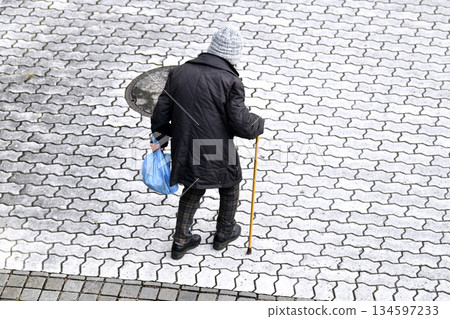 Yokohama cityscape in Japan: Hard-to-see steps and uneven surfaces...aging society...elderly woman with a cane...chilling with the winter solstice Yokohama cityscape in Japan: Hard-to-see steps and uneven surfaces...aging society...elderly woman with a cane...chilling with the winter solstice 134597233