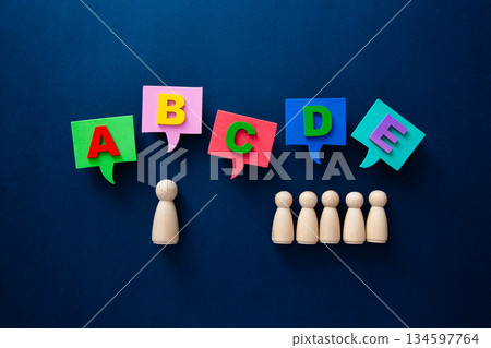 Wooden figures communicating ideas with colorful alphabet speech bubbles Wooden figures communicating ideas with colorful alphabet speech bubbles 134597764