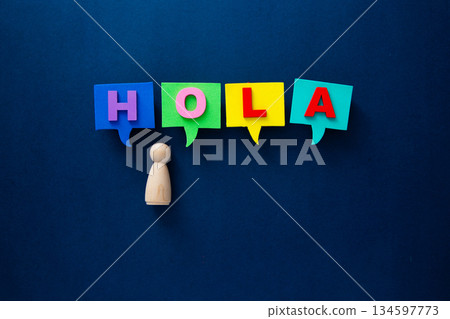 Wooden peg doll with speech bubbles spelling hola Wooden peg doll with speech bubbles spelling hola 134597773