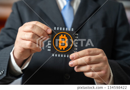 A businessman holds a chip with a Bitcoin symbol. Cryptocurrency industry. Blockchain infrastructure, digital asset. Crypto market. Exchanges and devices for storing cryptocurrencies offline. A businessman holds a chip with a Bitcoin symbol. Cryptocurrency industry. Blockchain infrastructure, digital asset. Crypto market. Exchanges and devices for storing cryptocurrencies offline. 134598422