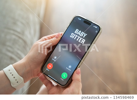 Woman receives a call from the babysitter. Childcare and supervision. Delegation of household chores. Work life balance and home management. Daily life planning. Trust and responsibility 134598469