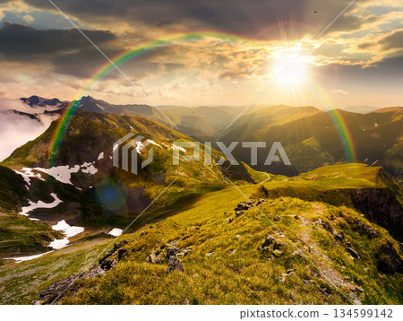 beautiful landscape of mountains at sunset. summer scenery with cloudy sky in evening light. Lake down the hillside. grass and snow on alpine slopes. hope, expectation, new beginning and bright future beautiful landscape of mountains at sunset. summer scenery with cloudy sky in evening light. Lake down the hillside. grass and snow on alpine slopes. hope, expectation, new beginning and bright future 134599142
