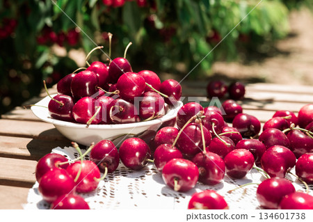 still life of cherries in white bowl on table in garde 134601738