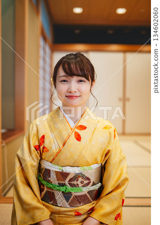 一位身穿和服的年輕女子坐在日式房間。 一位身穿和服的年輕女子坐在日式房間。 134602060
