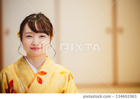 一位身穿和服的年輕女子坐在日式房間。 一位身穿和服的年輕女子坐在日式房間。 134602063