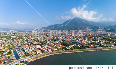 Aerial view of Fethiye coastal city in Turkey with residential area, waterfront road, sea and mountains in the background. Sunny day urban landscape by the Mediterranean coast.  134602121