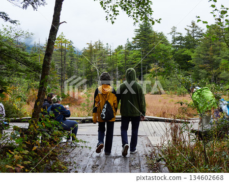 Tourists strolling through the Tashiro Marsh in Kamikochi, a popular tourist spot, on a rainy day Tourists strolling through the Tashiro Marsh in Kamikochi, a popular tourist spot, on a rainy day 134602668