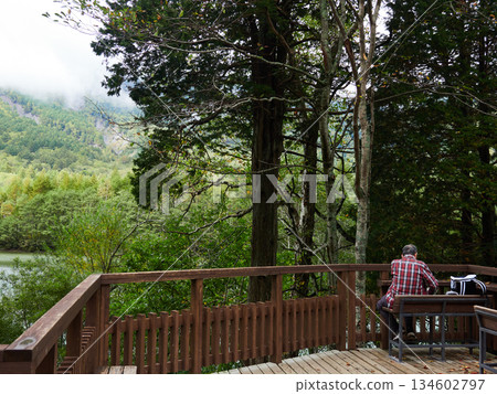 一位男遊客在熱門旅遊景點上高地大正池休息區休息。 一位男遊客在熱門旅遊景點上高地大正池休息區休息。 134602797
