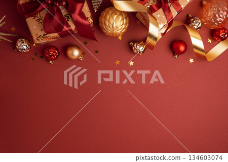 Border from Gold Wrapped Christmas Gifts with Red Ribbons and Ornaments on Red Background Border from Gold Wrapped Christmas Gifts with Red Ribbons and Ornaments on Red Background 134603074