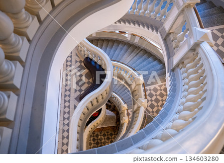 Elegant spiral staircase with classic balustrade and tiled floor Elegant spiral staircase with classic balustrade and tiled floor 134603280