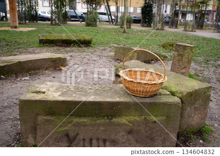 Woven basket on old stone bench in a park Woven basket on old stone bench in a park 134604832
