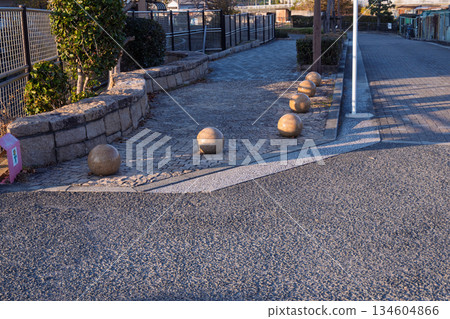 A bollard at the entrance to the Nishijogawa Promenade and its long shadow: a non-slip surface and infrastructure in the evening 134604866