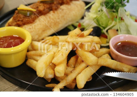 Chili hot dogs with fries and salad Chili hot dogs with fries and salad 134604905