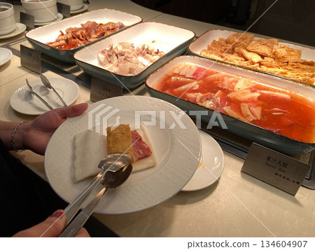 在飯店的高級自助餐中夾起了火腿片 134604907