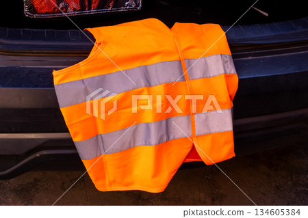 Reflective vest resting on the trunk of a car. Travel safety concept 134605384