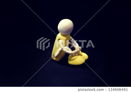 一張木偶抱著膝蓋的照片。照片中瀰漫著孤獨、沮喪、悔恨、悲傷和負面情緒。 134606491