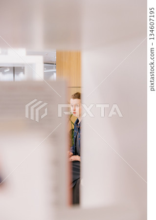young woman is sitting and working on laptop against background of green monstera. young woman is sitting and working on laptop against background of green monstera. 134607195