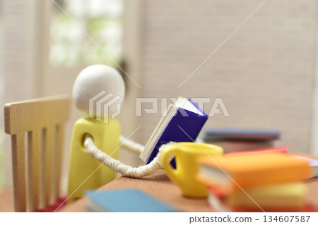 一張木偶閱讀的照片，周圍堆滿了書，是業餘愛好和學習的場景。 134607587