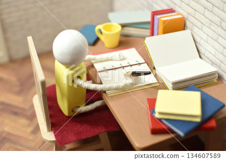 一張木偶在筆記本上寫字的照片，學習，寫作，作業 134607589
