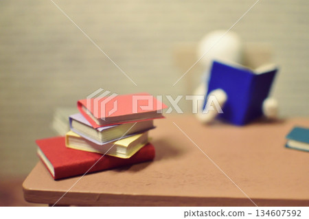 一張木偶閱讀的照片，周圍堆滿了書籍，業餘時間，學習，微縮模型 134607592