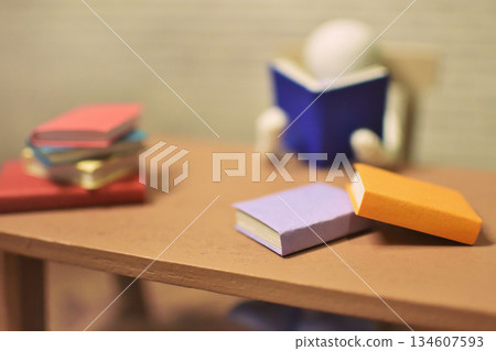 一張木偶閱讀的照片，周圍堆滿了書籍，業餘時間，學習，微縮模型 134607593