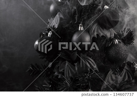 Gothic Christmas. A black Christmas tree adorned with dark ornaments and surrounded by mist Gothic Christmas. A black Christmas tree adorned with dark ornaments and surrounded by mist 134607737