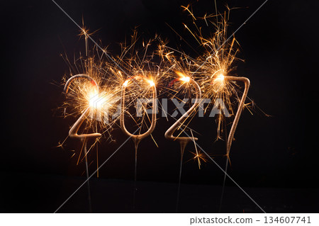 Sparkling 2027 Celebration. Bright sparklers forming 2027 against a dark background 134607741
