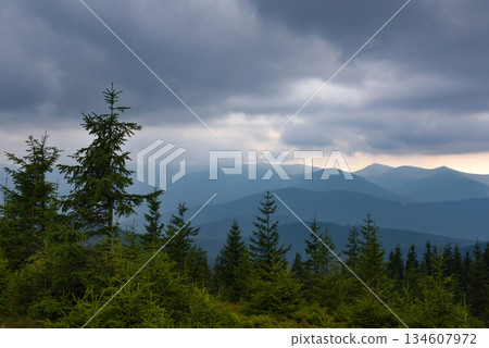 Wonderful summer panorama with mountains. A thunderstorm is coming. Rain Clouds Above Mountains. 134607972