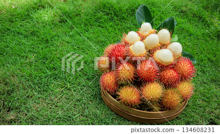 Ripe fresh rambutan in basket showing white flesh, organic tropical fruit, healthy food  134608231