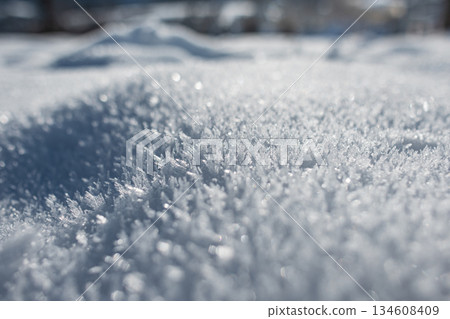 Stunning macro view of delicate hoarfrost needles glistening under bright sunlight. Shimmering winter texture, perfect for abstract and seasonal backgrounds. Snow close-up Stunning macro view of delicate hoarfrost needles glistening under bright sunlight. Shimmering winter texture, perfect for abstract and seasonal backgrounds. Snow close-up 134608409