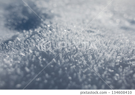 Close-up of frozen ice crystals sparkling in the sun. A detailed, pure white and blue winter texture with shallow depth of field for abstract designs. Holidays and snow 134608410