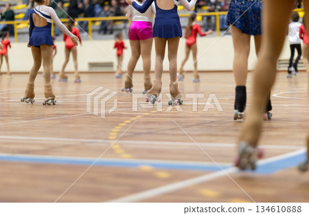 Girls roller skating on wooden sport court during performance Girls roller skating on wooden sport court during performance 134610888