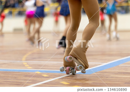 Legs of a roller skater performing on wooden court 134610890