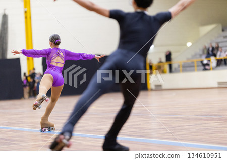 Pair artistic roller skaters performing dynamic routine 134610951
