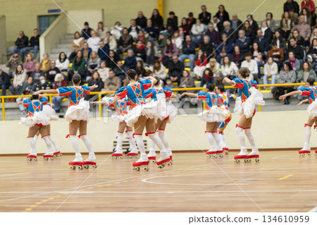 Group of young women roller skating performing in an arena 134610959