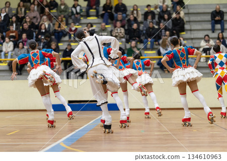 Skaters performing artistic roller skating routine in colorful costumes 134610963