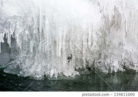 frozen waterfall close up view. icicles hanging above water. cold winter landscape photography on river tyrychka of transcarpathia ukraine. seasonal nature texture. background for climate change 134611000