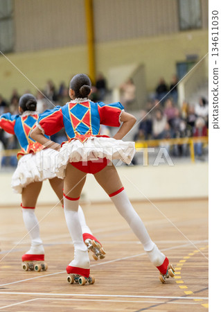 Young artistic roller skaters performing elegant routine indoors 134611030