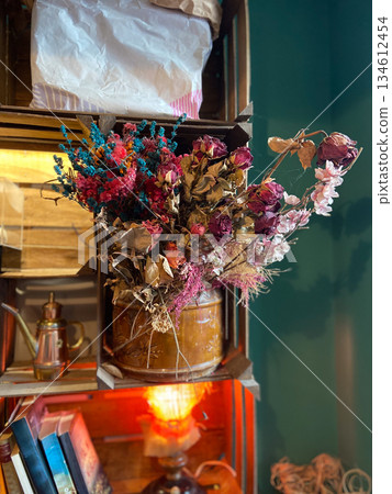 Dried flower bouquet arranged on wooden shelf indoors. Vintage decor styling, nostalgic atmosphere, botanical texture and cozy interior still life composition. 134612454