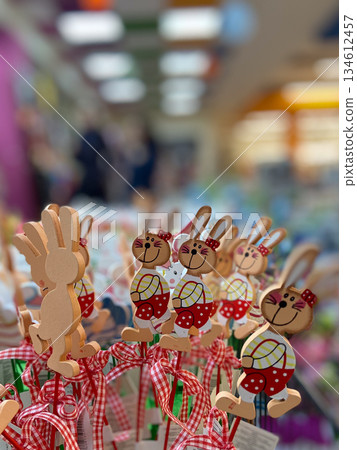 Wooden bunny decorations displayed at seasonal market stall. Festive assortment, spring celebration, handcrafted charm and joyful holiday retail atmosphere. Wooden bunny decorations displayed at seasonal market stall. Festive assortment, spring celebration, handcrafted charm and joyful holiday retail atmosphere. 134612457