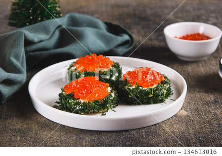 Original small sandwiches with butter and red caviar on a plate on the table 134613016