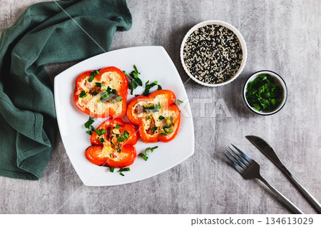 Fried red bell pepper rings with omelette and herbs on a plate on the table top view 134613029