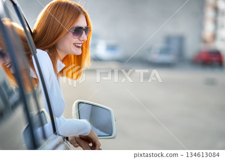 Young pretty woman driver in sunglasses looking out the car front window on a sunny summer day. Young pretty woman driver in sunglasses looking out the car front window on a sunny summer day. 134613084