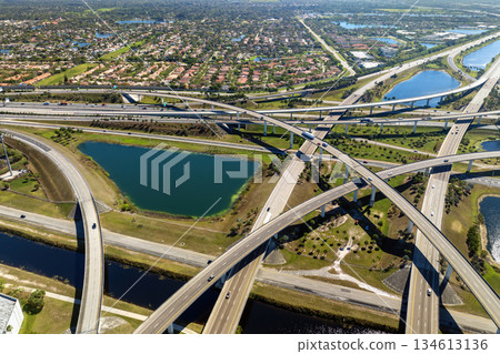 View from above of USA transportation infrastructure. American freeway intersection with fast driving cars and trucks in Miami, Florida View from above of USA transportation infrastructure. American freeway intersection with fast driving cars and trucks in Miami, Florida 134613136