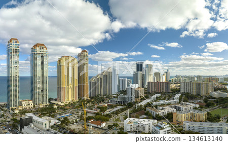 View from above of luxurious highrise hotels and condos on Atlantic ocean shore in Sunny Isles Beach city. American tourism infrastructure in southern Florida 134613140