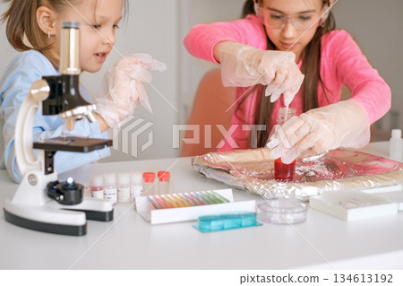 Children conduct a school experiment with mixing reagents and liquids in the classroom. Interests in chemistry and sciences Children conduct a school experiment with mixing reagents and liquids in the classroom. Interests in chemistry and sciences 134613192