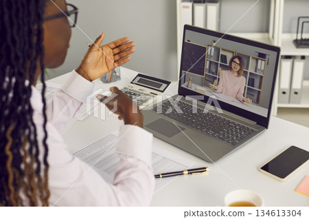 Woman business accountant having discussion with teacher via video call on laptop Woman business accountant having discussion with teacher via video call on laptop 134613304